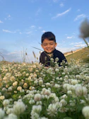 A candid shot of a smiling child playing in a field of wildflowers, full of life and hope.