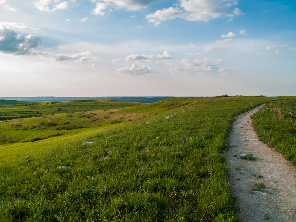 A gravel nature trail over green hills on the Konza Prairie in the Flint Hills, Kansas