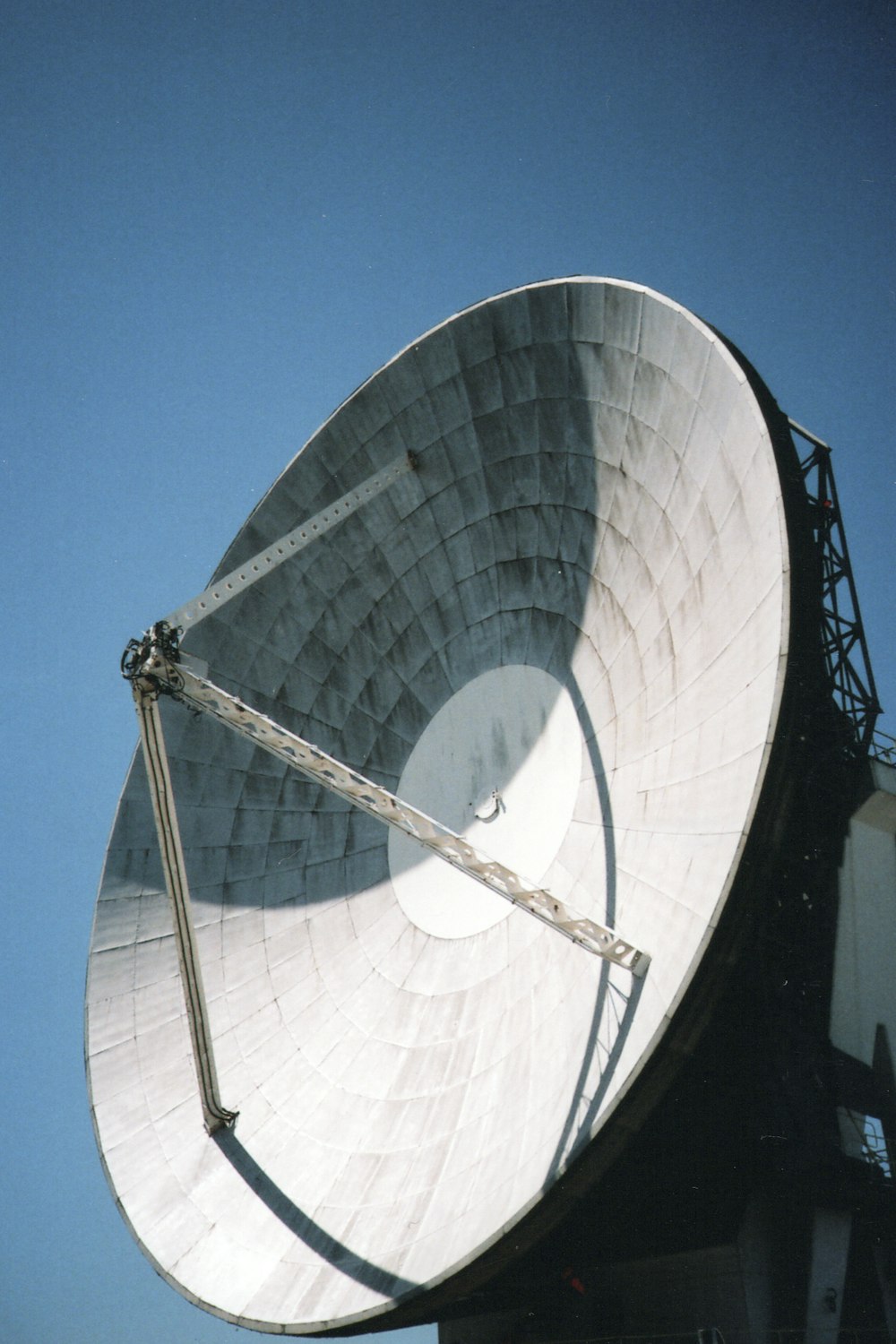 昼間の青空の下での白い衛星放送受信アンテナ