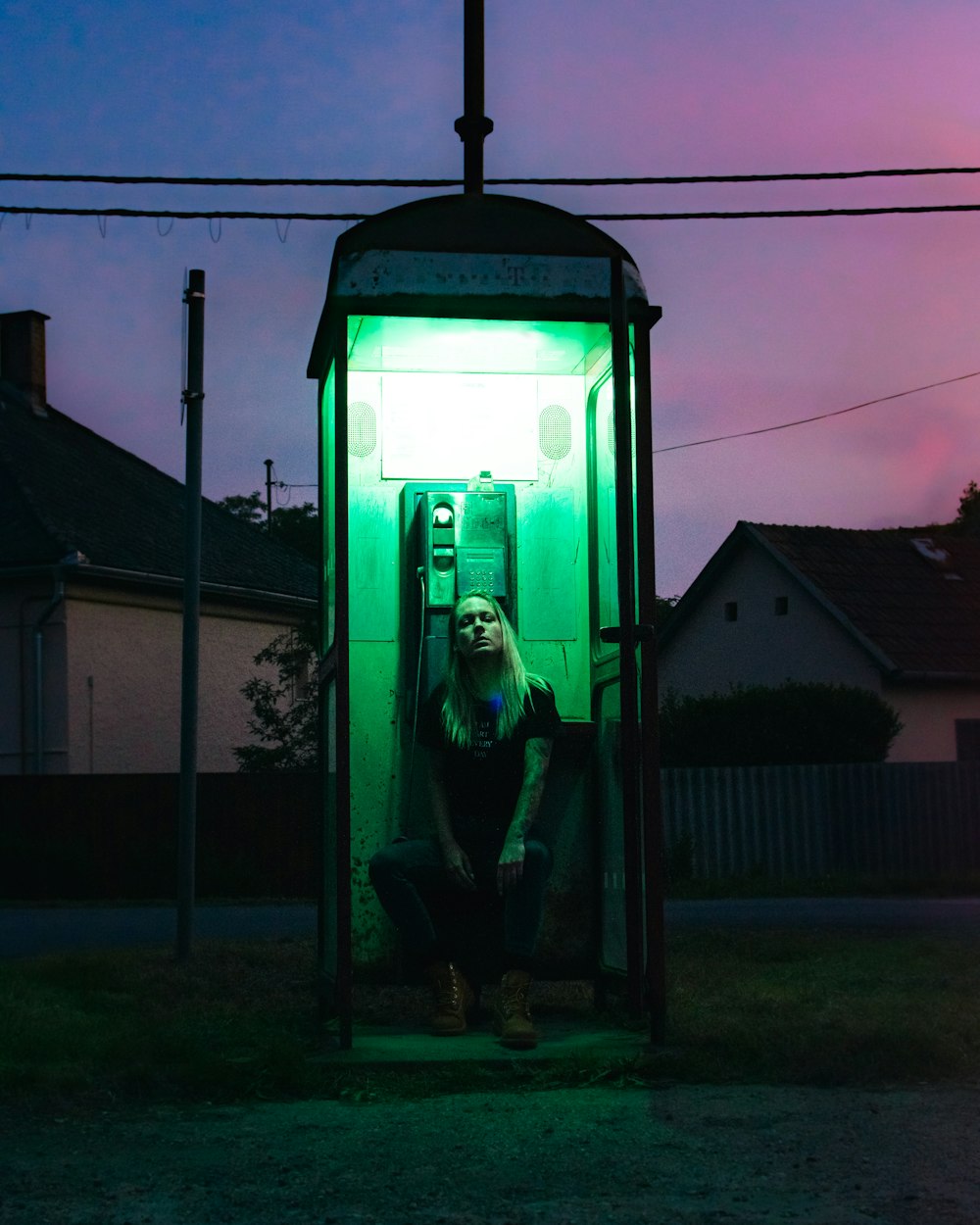 green telephone booth near brown house during daytime