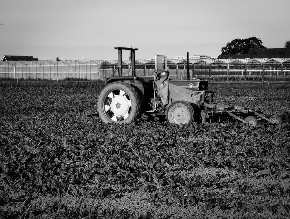 grayscale photo of tractor on grass field