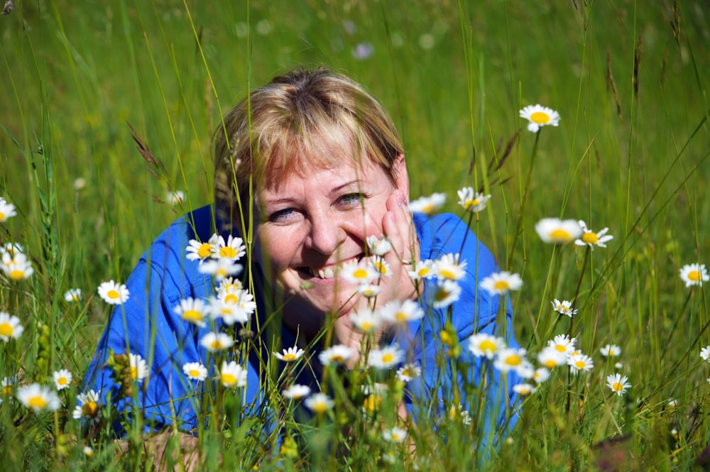 woman in blue and yellow floral shirt lying on green grass field