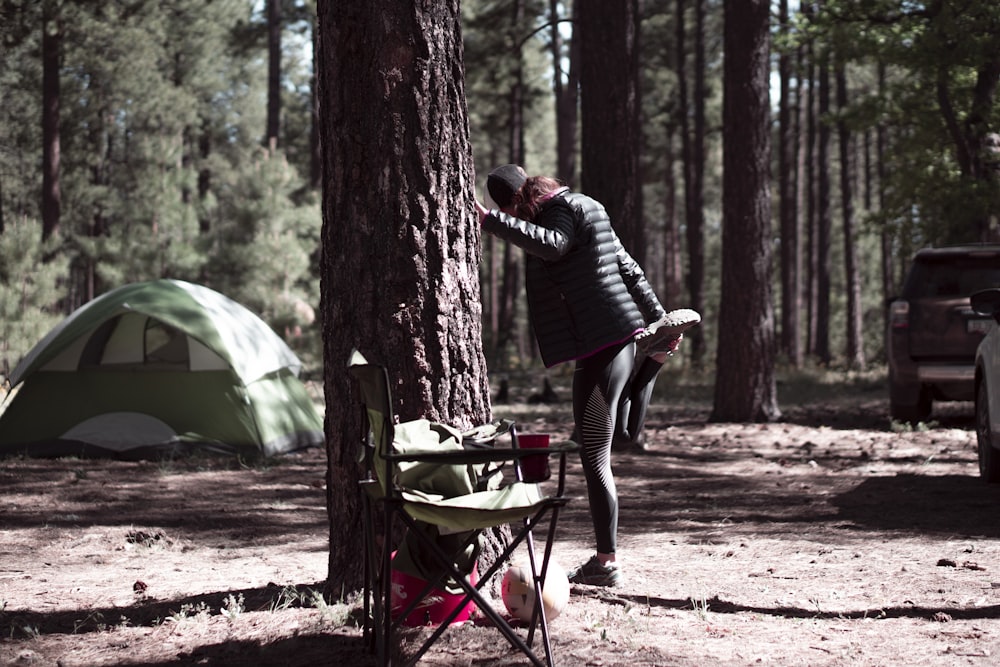man in black and white striped long sleeve shirt and black pants standing near tent