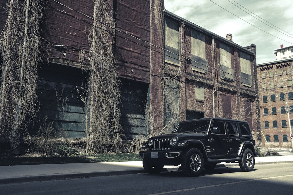 black jeep wrangler parked beside brown brick building
