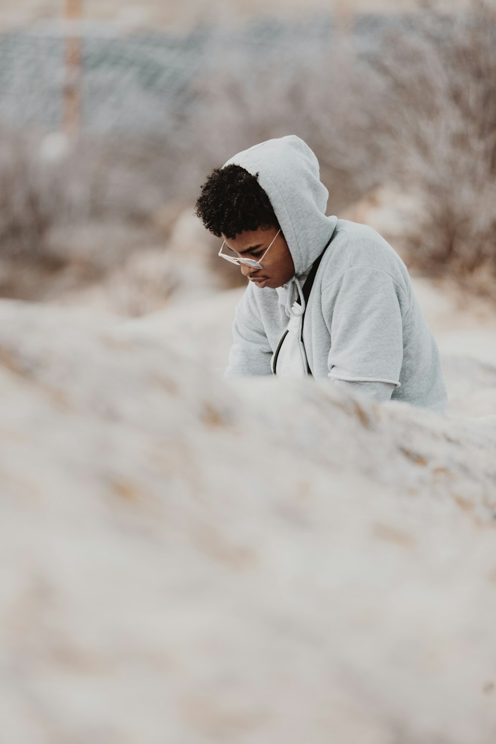 man in gray hoodie looking at the ground