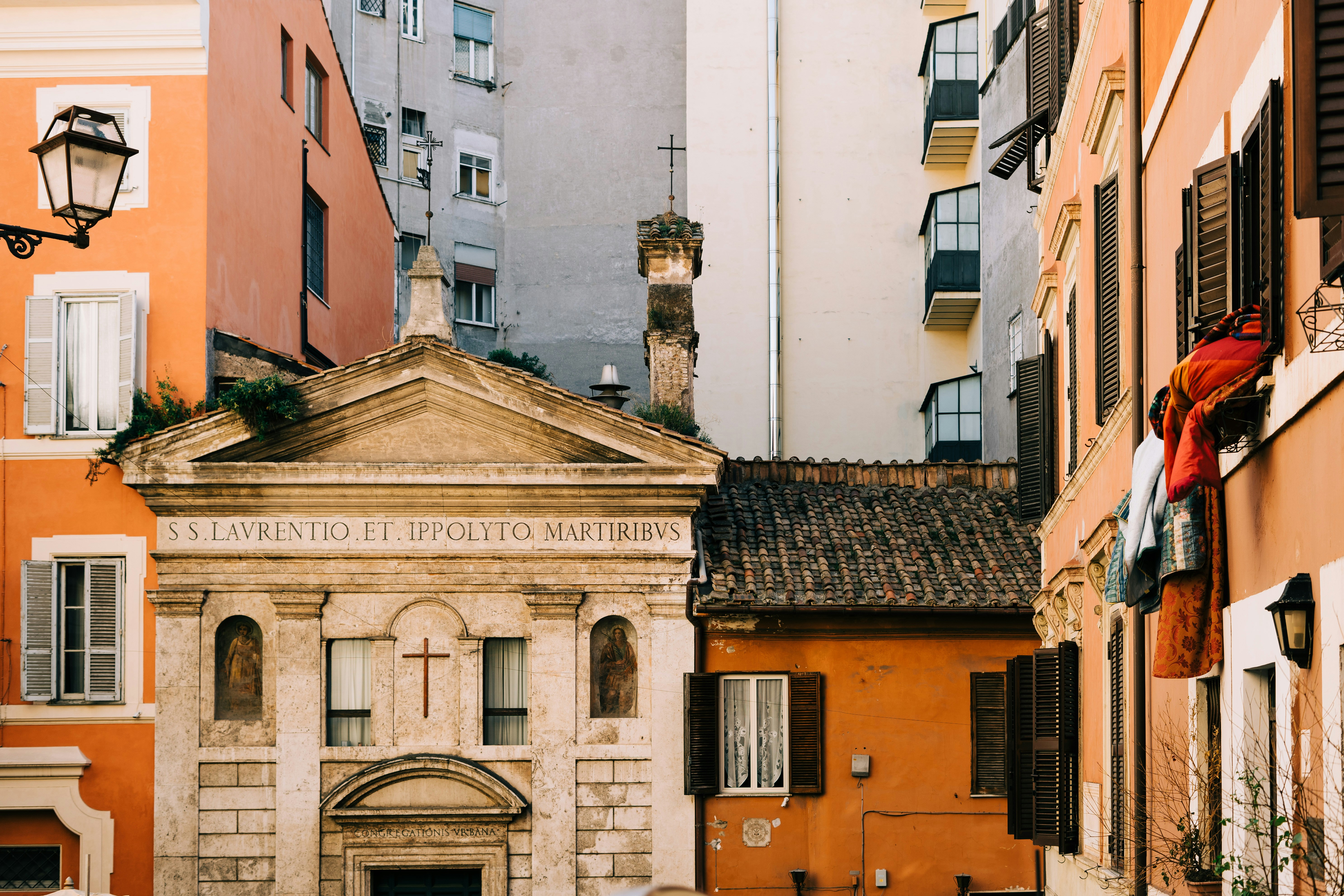 brown and white concrete building during daytime, Building juxtaposition in Rome’s Monti neighbourhood 