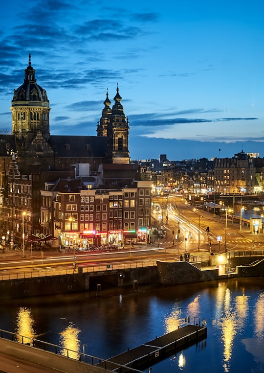 brown and white concrete building near body of water during night time in Church of Saint Nicholas Netherlands