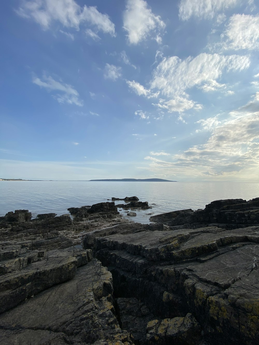 brown rocky shore under blue sky during daytime