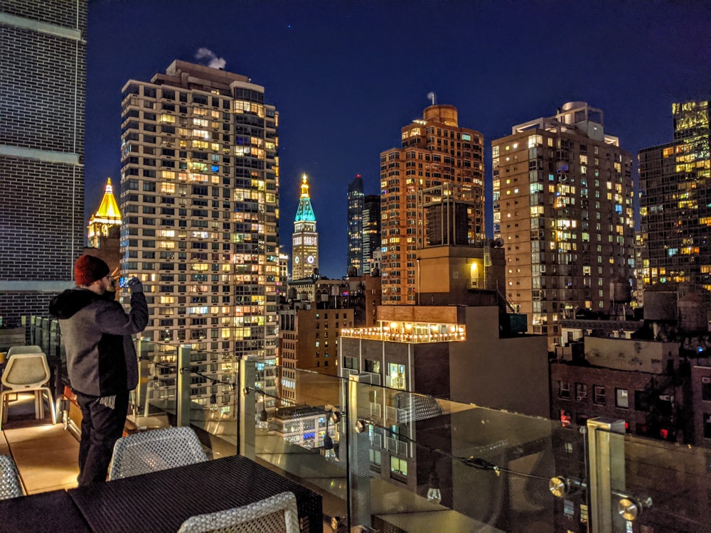man in black jacket standing on top of building during night time