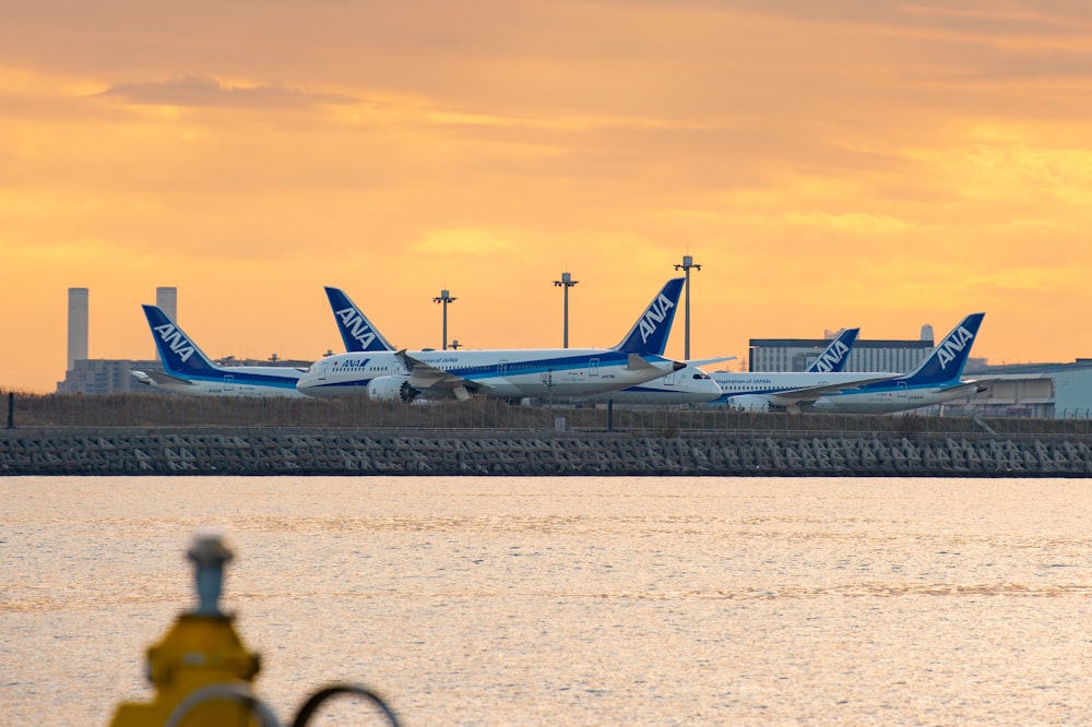 white and blue airplane on airport during daytime