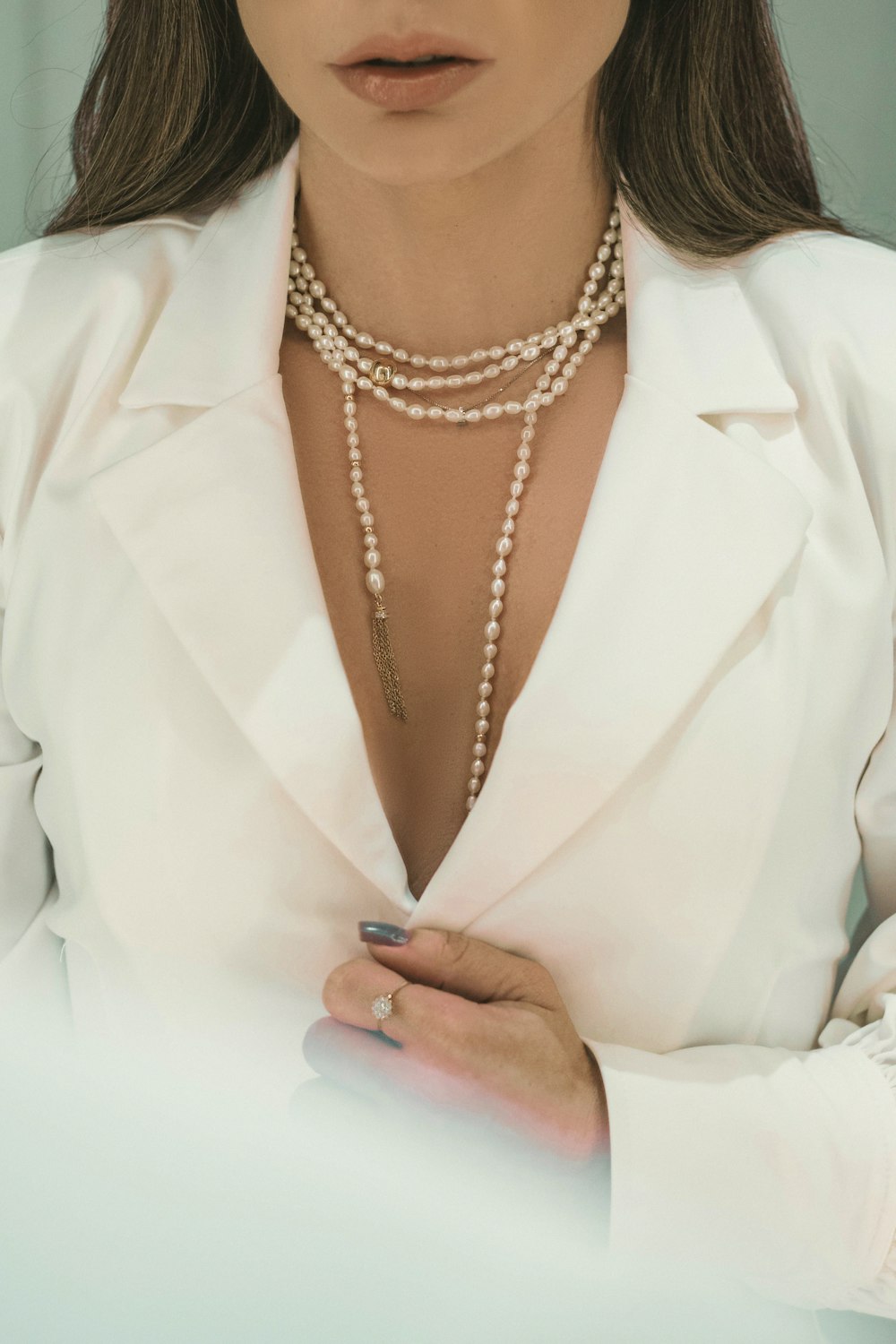 person wearing silver necklace and white robe