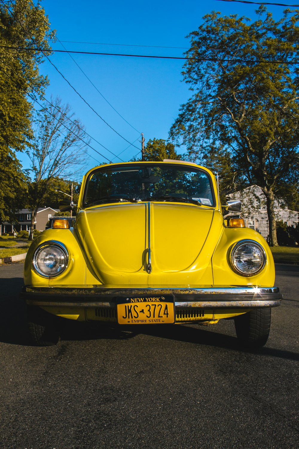 yellow volkswagen beetle parked on street during daytime