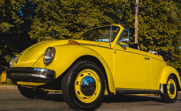 A vibrant blue convertible with its top down, shining after a full vehicle care service.