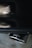 A close-up of a metallic exhaust pipe with a shiny surface, reflecting light and showing the brand logo imprinted on it. The background appears blurred, emphasizing the focus on the exhaust.