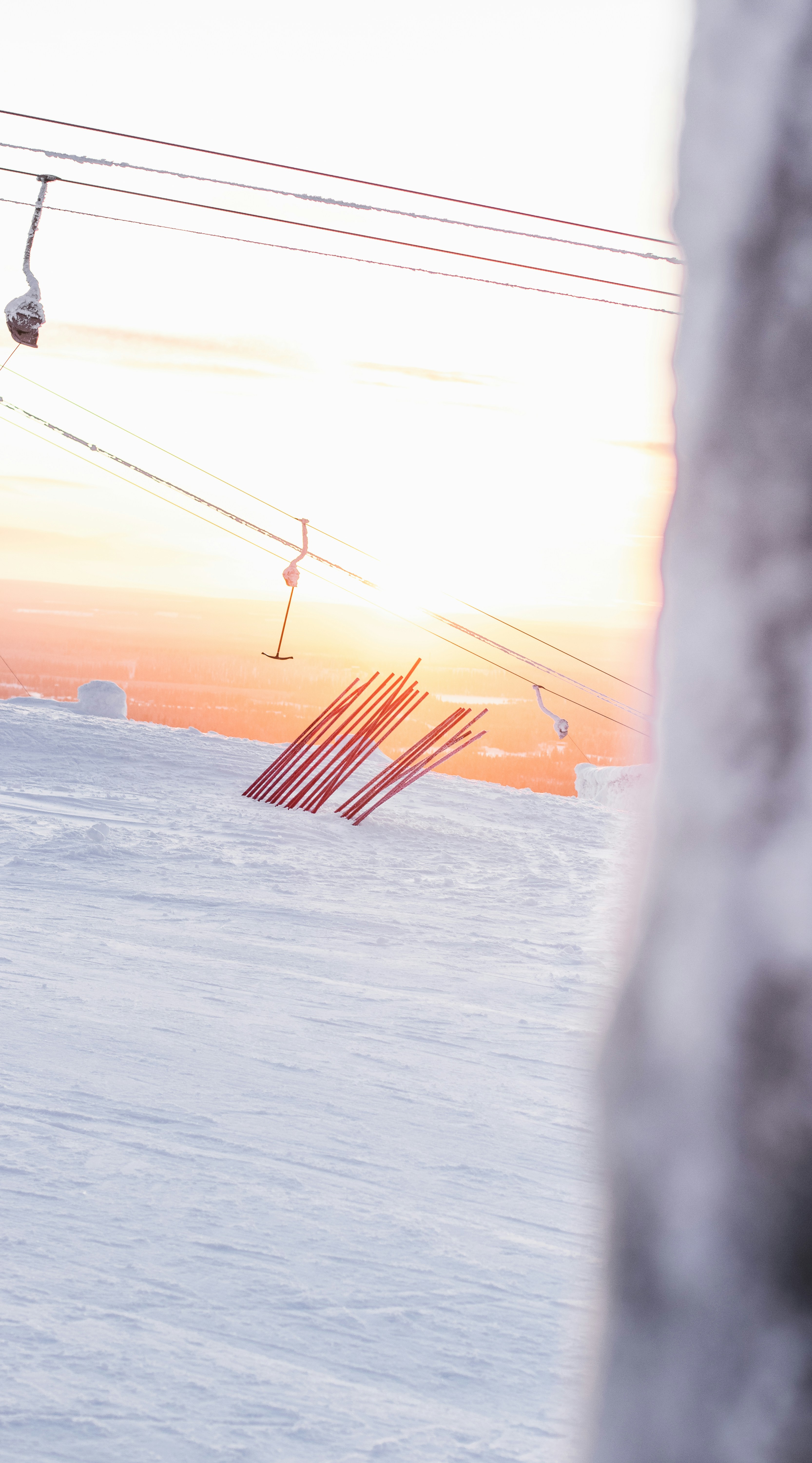 orange and white striped flag on white snow covered ground during daytime