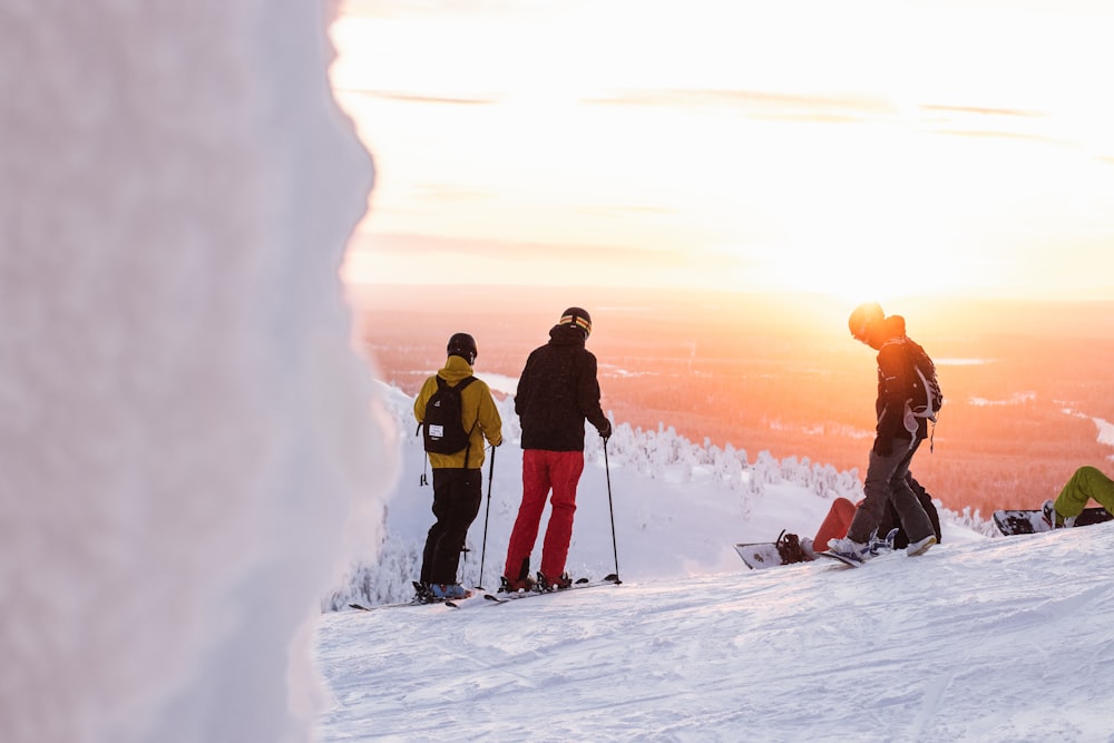 2 men in black and red jacket and black pants standing on snow covered ground during