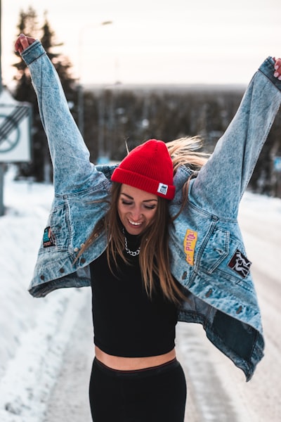 woman in blue denim jacket and red knit cap