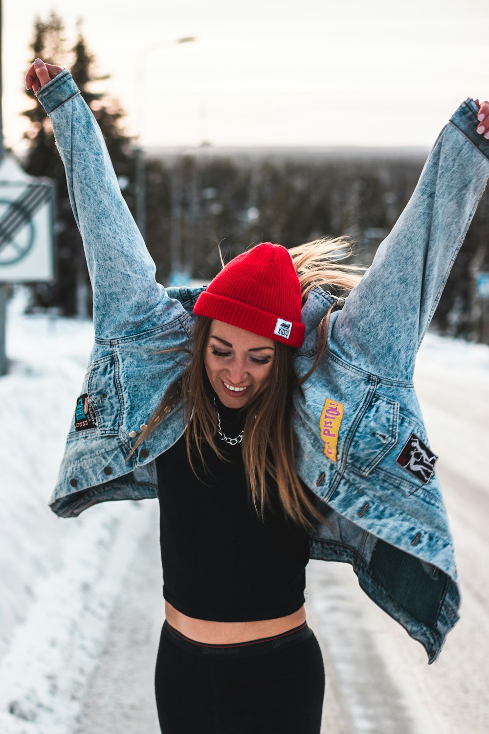 woman in blue denim jacket and red knit cap