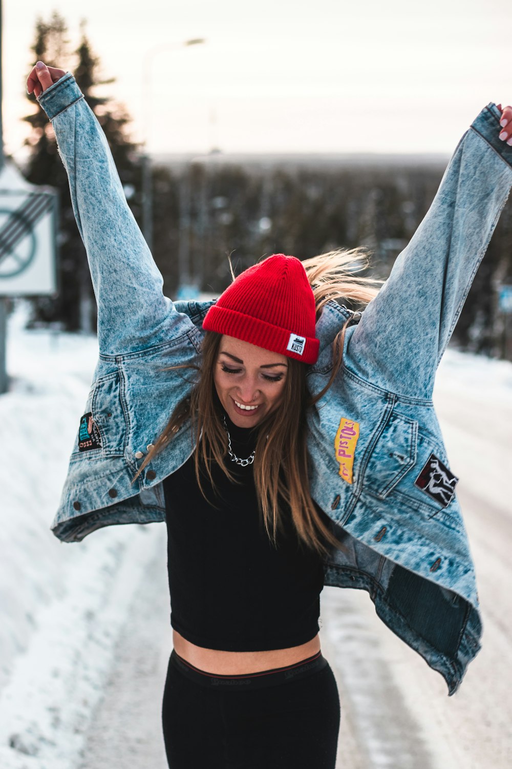 donna in giacca di jeans blu e berretto in maglia rossa