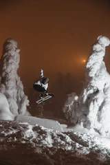 man in black jacket and black pants sitting on snow covered ground during daytime