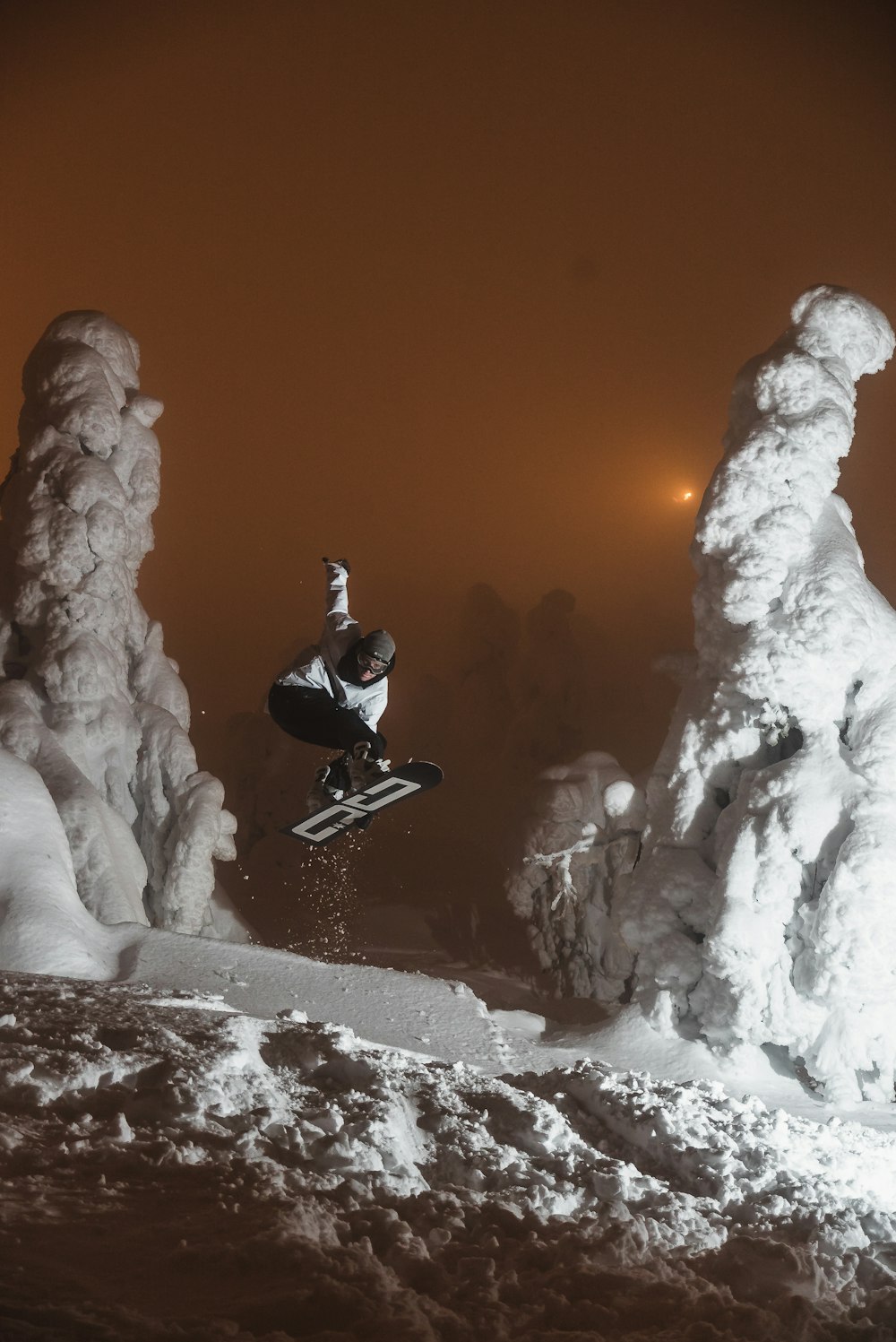 man in black jacket and black pants sitting on snow covered ground during daytime