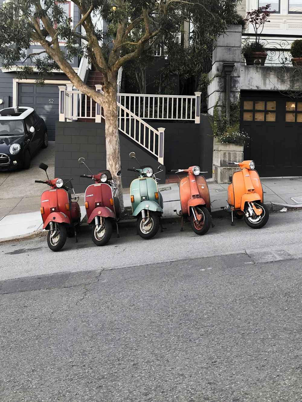 red and green motor scooter parked beside road during daytime