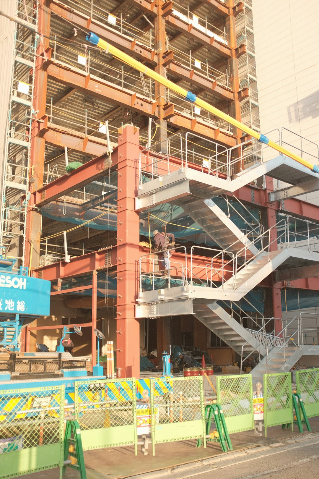 orange and blue building with green and yellow metal fence