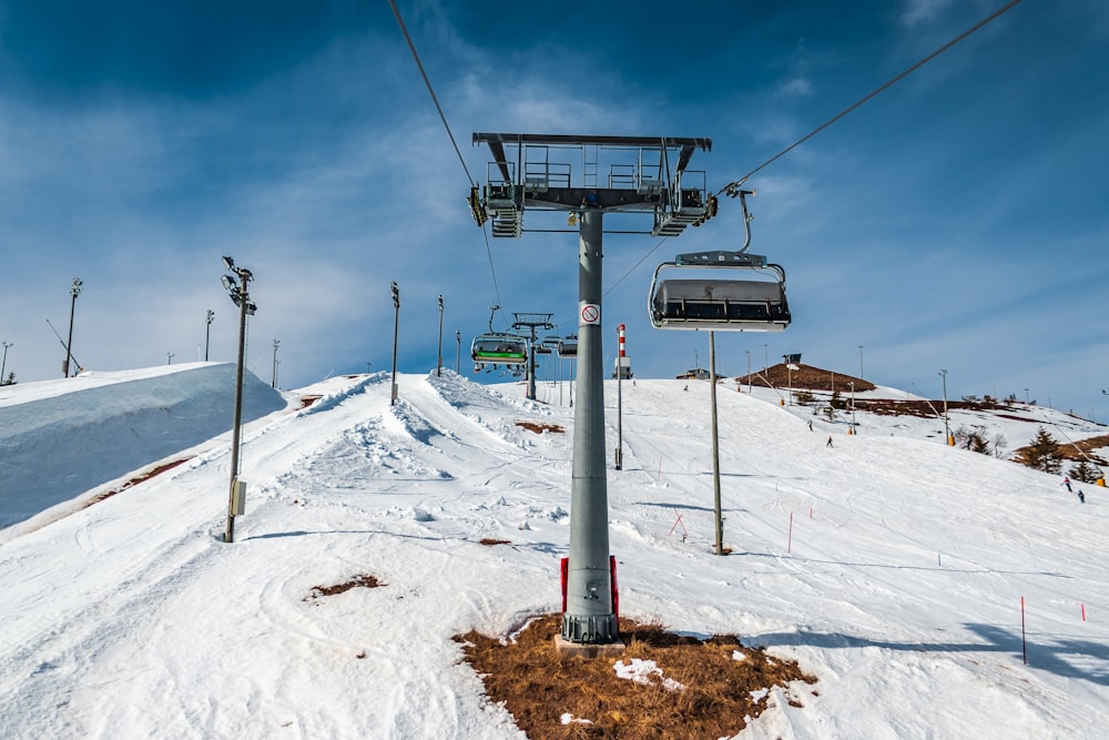 cable car over snow covered ground under blue sky during daytime