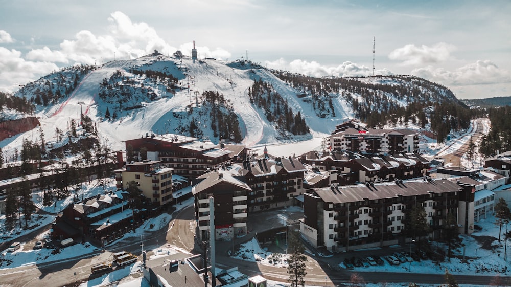 edifícios de concreto marrom e branco perto da montanha coberta de neve durante o dia