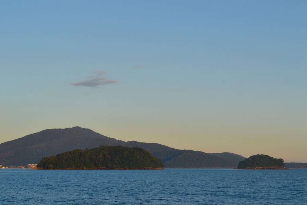 body of water near mountain during daytime