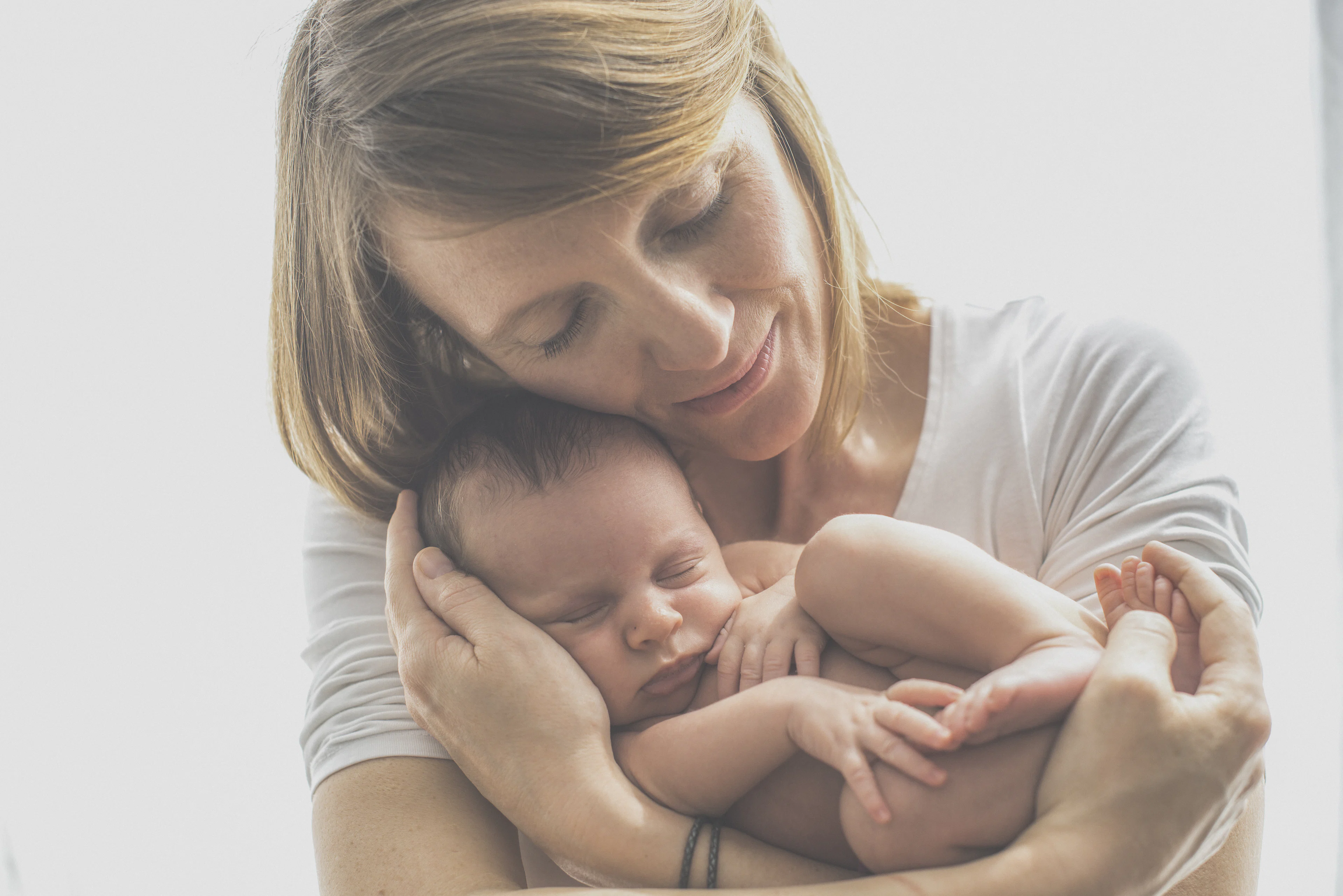 Mother holding her sleeping newborn baby close