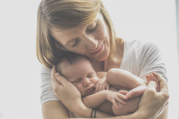 Mother in white shirt carrying baby