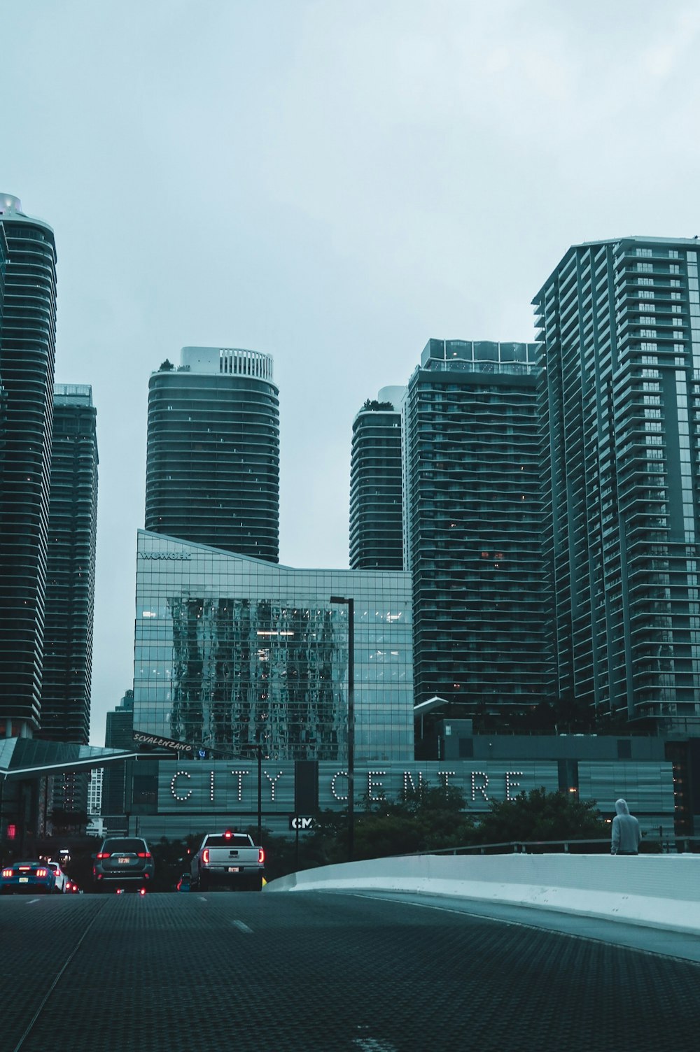 cars parked on parking lot near high rise building during daytime