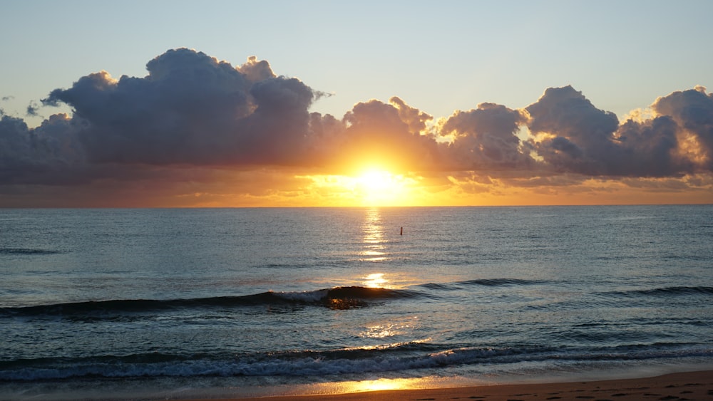 sea waves crashing on shore during sunset