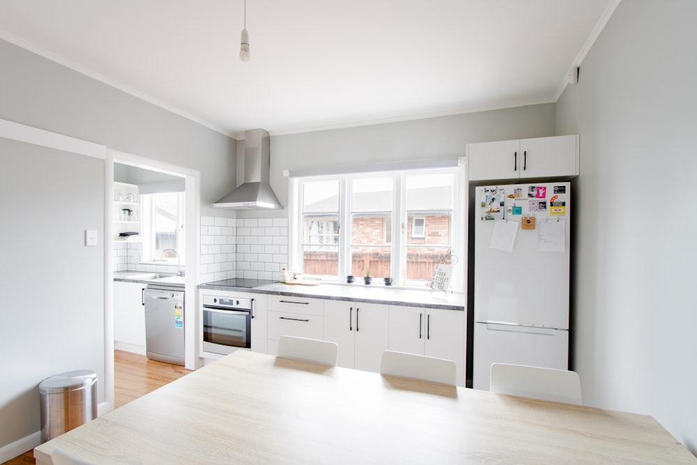 white wooden table near white wooden framed glass window