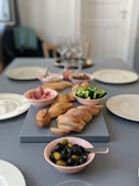 A table set for a Mediterranean meal with bread, wine, and small dishes.