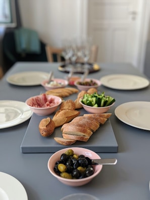 A table set for a Mediterranean meal with bread, wine, and small dishes.