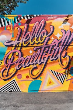 A vibrant mural featuring the phrase 'hello world!' painted with bright colors on a city wall.
