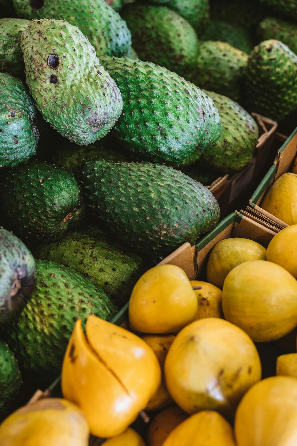 green and yellow fruits on brown wooden tray