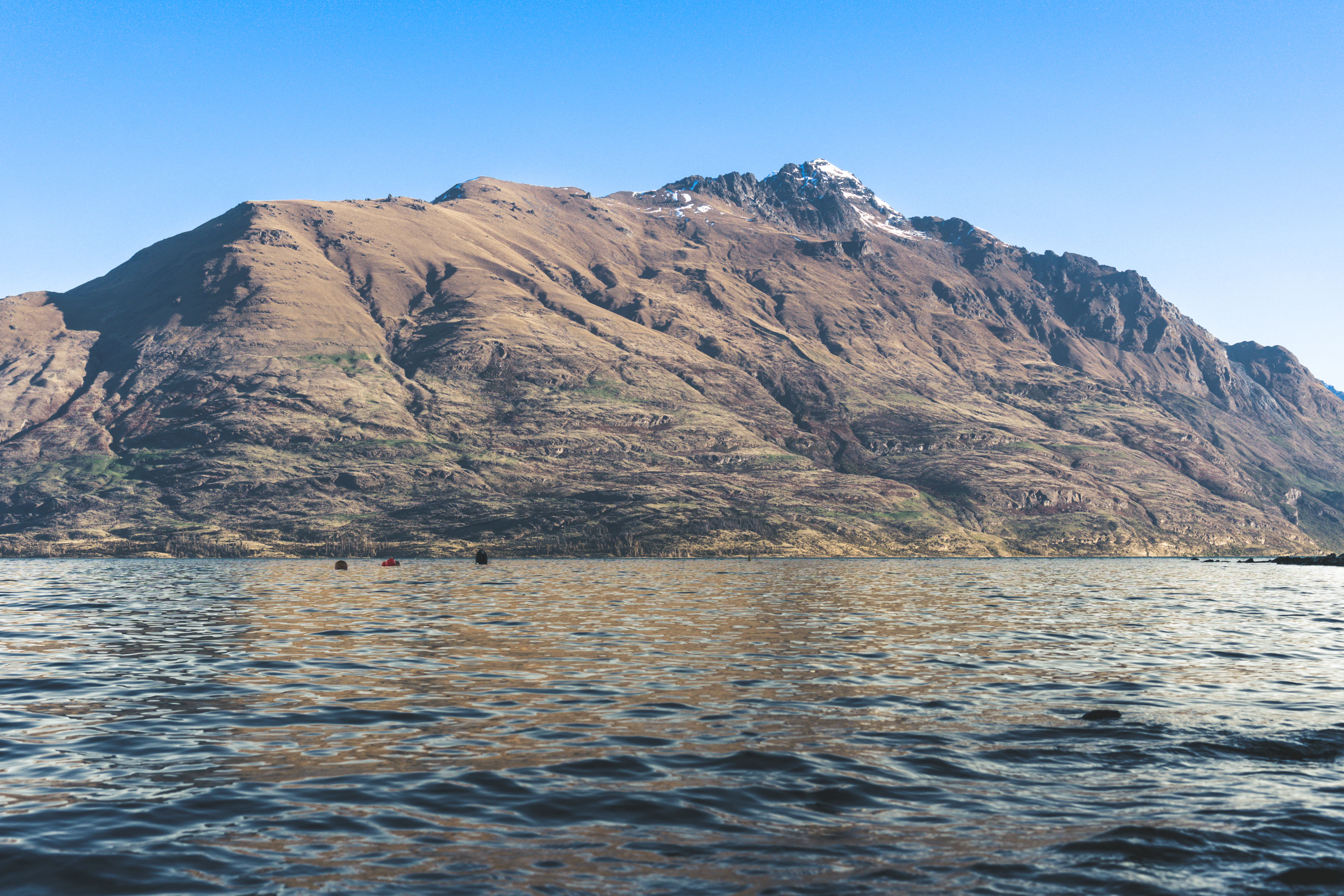 Cecil Peak in warm low light across the calm water of Lake Wakatipu near Queenstown, New Zealand