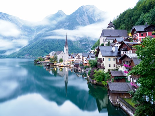 houses near lake and mountains during daytime in Hallstatt Austria Austria