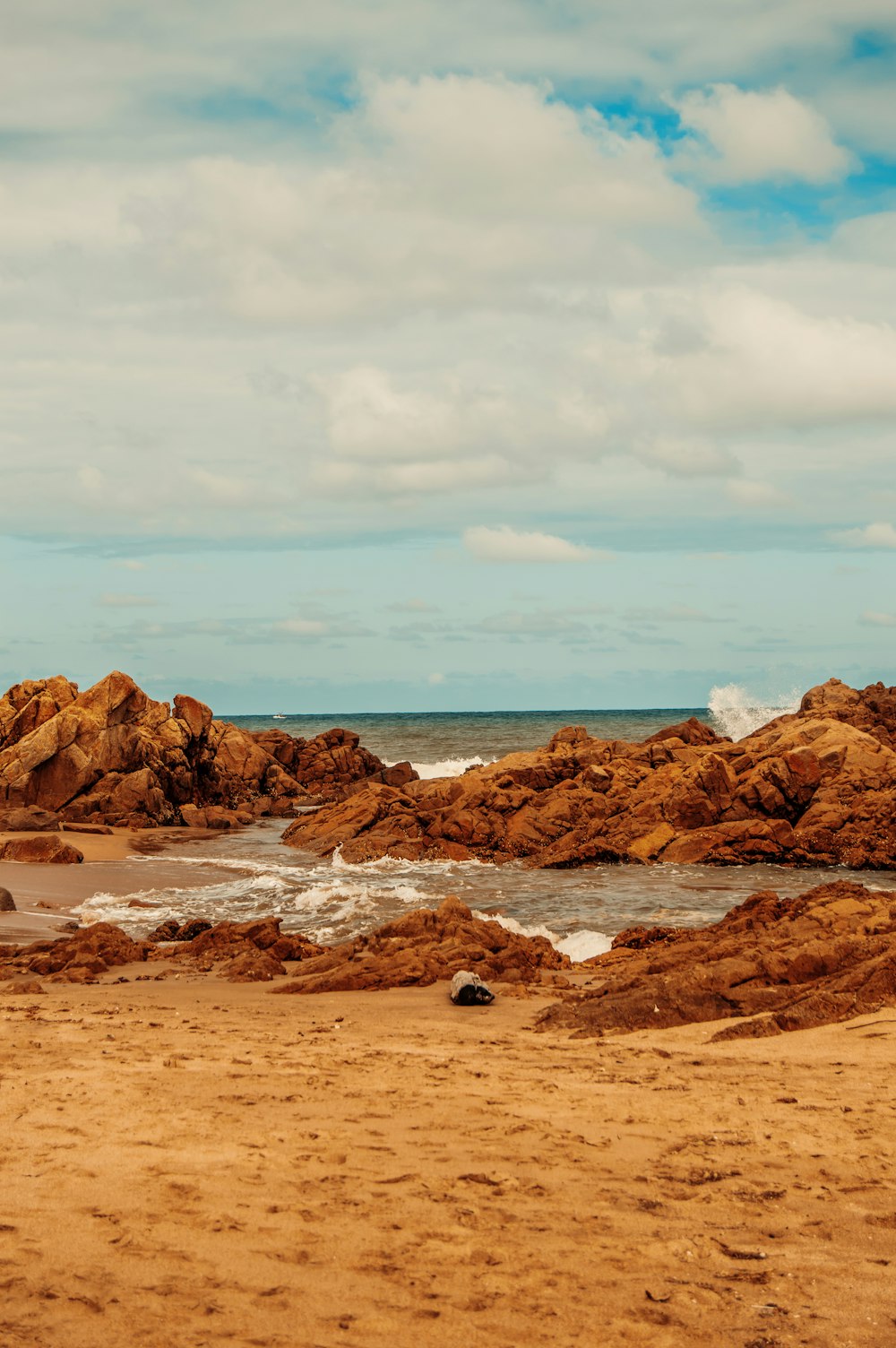 Formazione rocciosa marrone in riva al mare durante il giorno