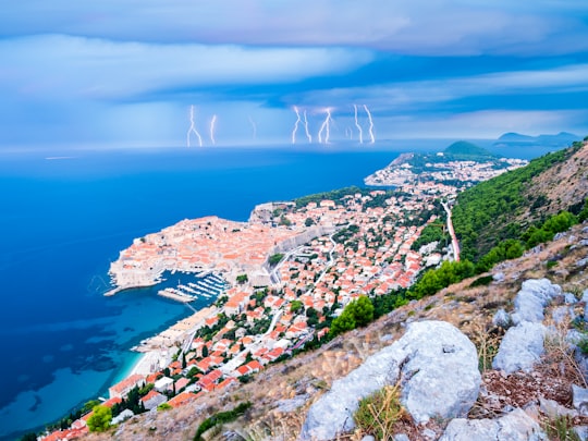 aerial view of city near body of water during daytime in Muralles de Dubrovnik Croatia