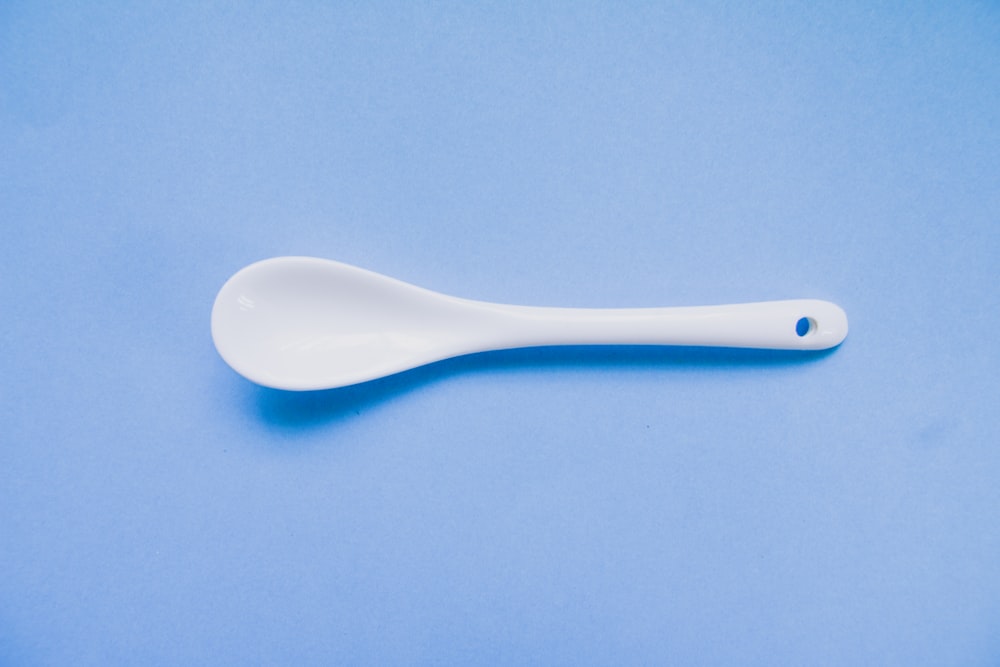white plastic spoon on blue textile