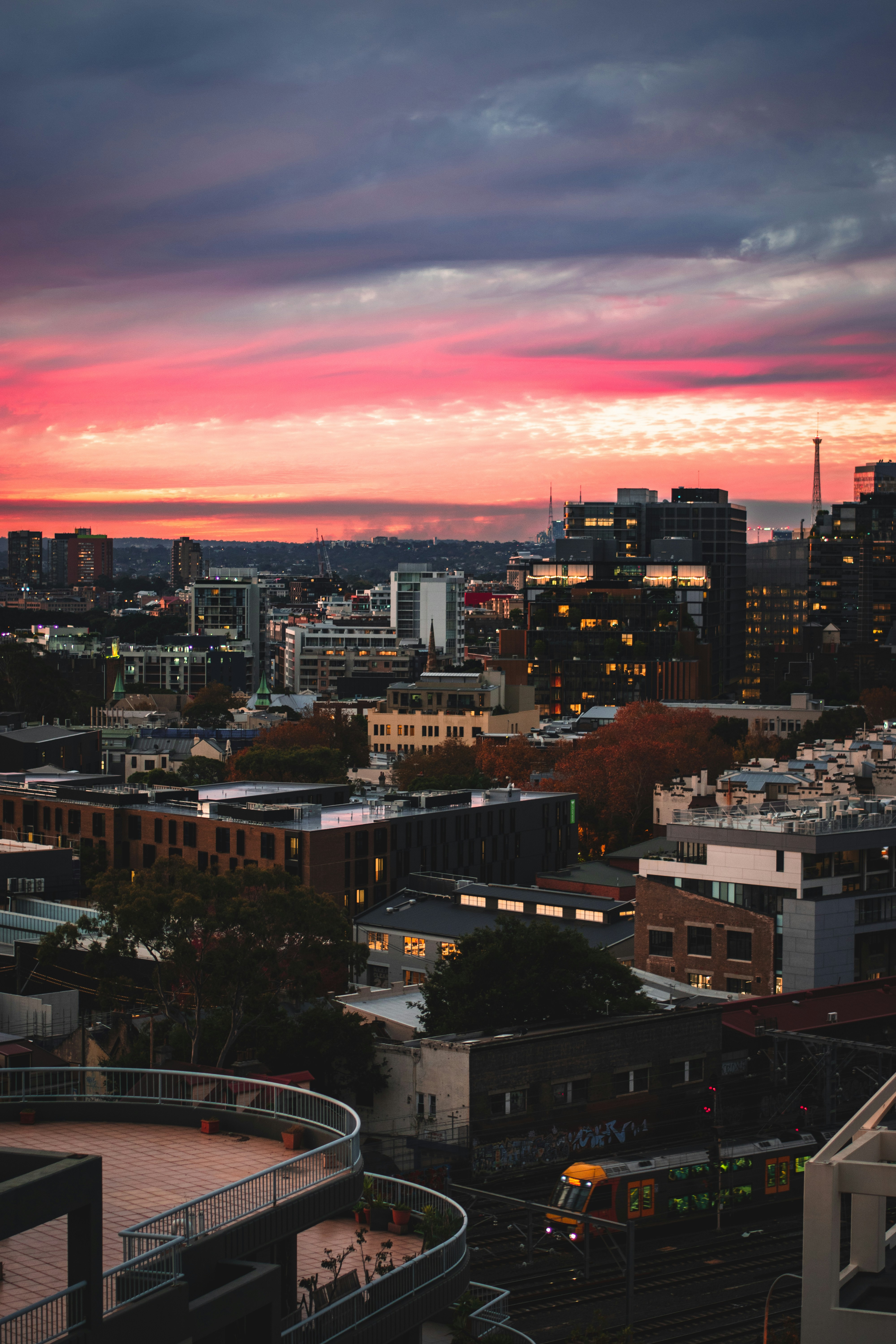 city with high rise buildings under orange and blue sky