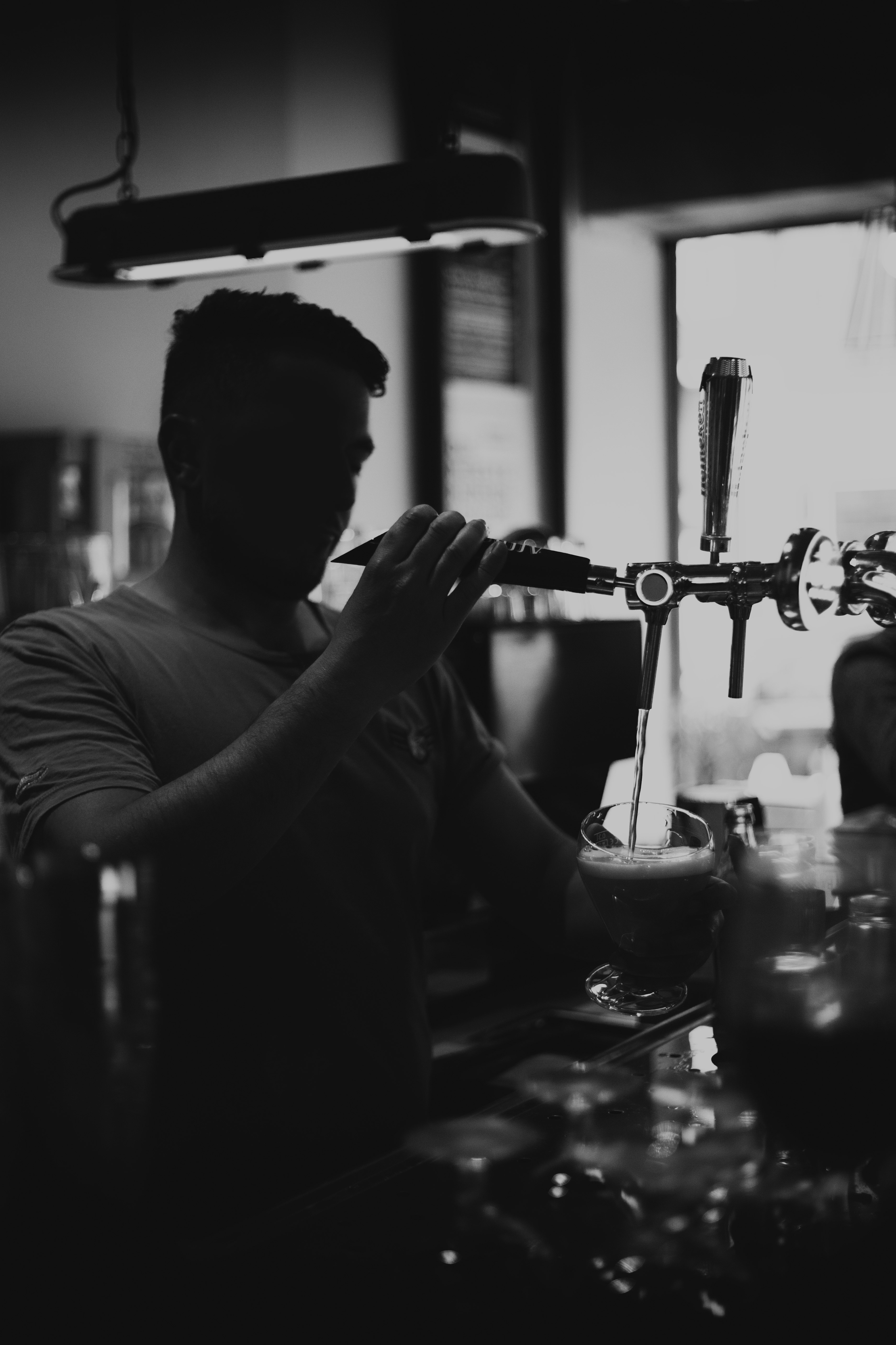 man in crew neck t-shirt holding clear drinking glass