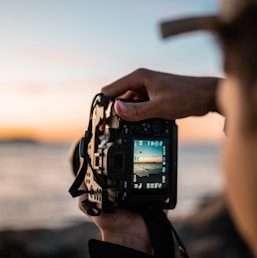 person holding black dslr camera