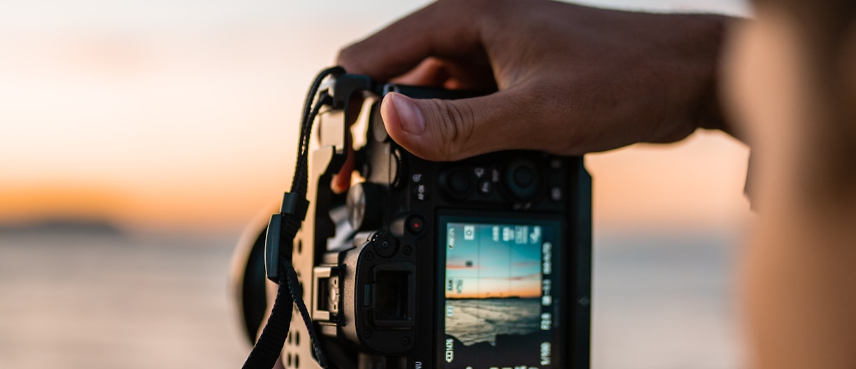 person holding black dslr camera