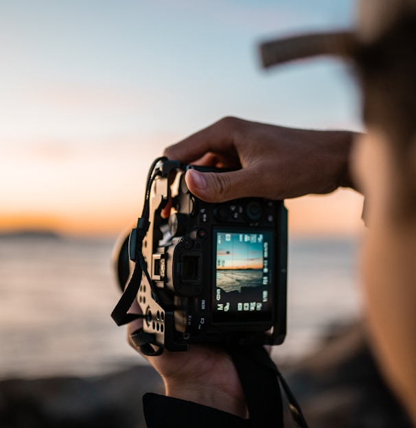 person holding black dslr camera