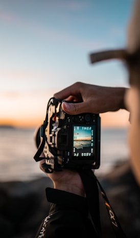 person holding black dslr camera